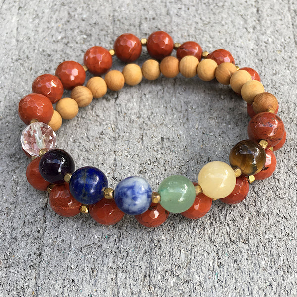 This double wrap stretchy mala bracelet contains 27, 8 mm gemstones & sandalwood beads. Of which are 7 round smooth chakra gemstones, 1 round faceted clear crystal quartz gemstone, and 19 round faceted red jasper gemstones. Gemstones are separated by 2mm German Silver brass plated spacer beads. 6mm round smooth sandalwood beads are used to complete the quarter mala bracelet design.