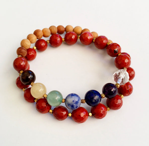 This double wrap stretchy mala bracelet contains 27, 8 mm gemstones & sandalwood beads. Of which are 7 round smooth chakra gemstones, 1 round faceted clear crystal quartz gemstone, and 19 round faceted red jasper gemstones. Gemstones are separated by 2mm German Silver brass plated spacer beads. 6mm round smooth sandalwood beads are used to complete the quarter mala bracelet design.