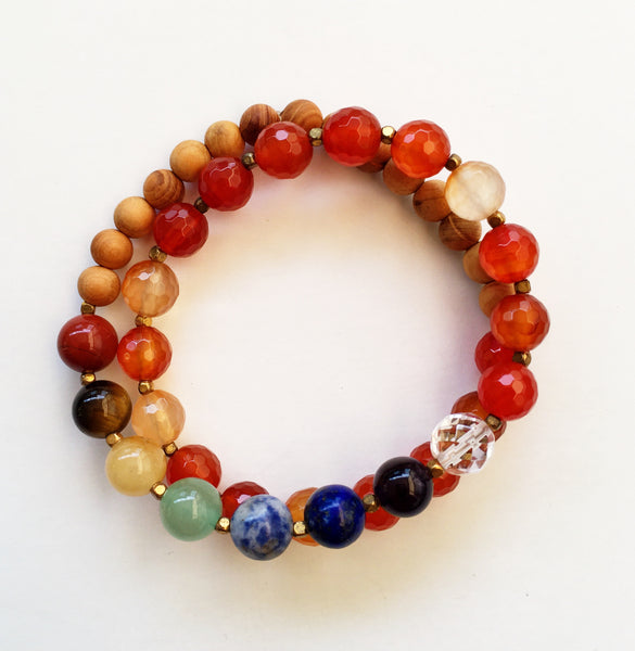 This double wrap stretchy mala bracelet contains 27, 8 mm gemstones & sandalwood beads. Of which are 7 round smooth chakra gemstones, 1 round faceted clear crystal quartz gemstone, and 19 round faceted carnelian gemstones. Gemstones are separated by 2mm German Silver brass-plated spacer beads. 6mm round smooth sandalwood beads are used to complete the quarter mala bracelet design.