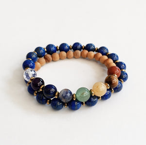 This double wrap stretchy mala bracelet contains 27, 8 mm gemstones & sandalwood beads. Of which are 7 round smooth chakra gemstones, 1 round faceted clear crystal quartz gemstone, and 19 round smooth lapis lazuli gemstones. Gemstones are separated by 2mm Hematite plated spacer beads. 6mm round smooth sandalwood beads are used to complete the quarter mala bracelet design.